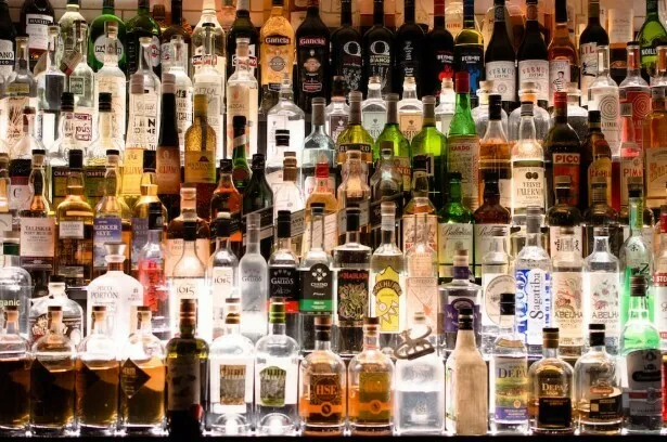 Shelves of liquor bottles behind a bar