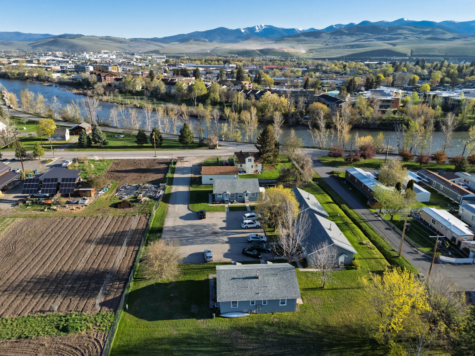 Aerial view of a neighborhood along a river with mountains in the distance
